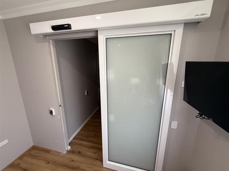 White automatic internal sliding door with accessible wall control